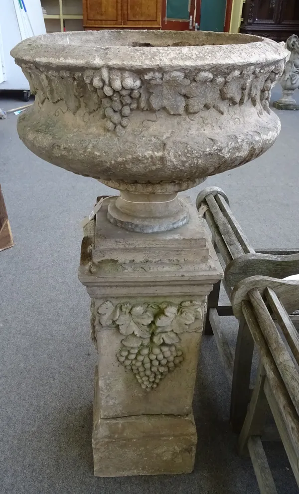 A pair of reconstituted stone jardinieres, of circular form on stepped square pedestals, relief moulded with fruiting vines, 65cm diameter x 120cm hig