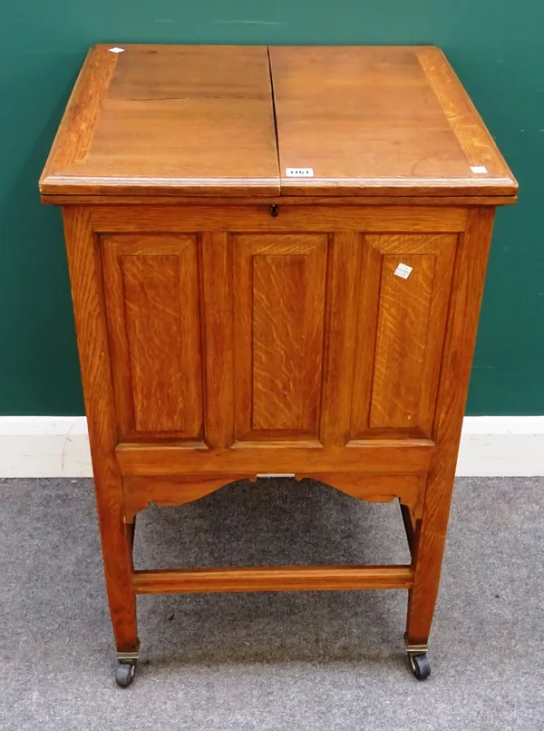 An Edwardian oak decanter/drinks table, the fold out top revealing a fitted interior, on square supports, 57cm wide x 90cm high.