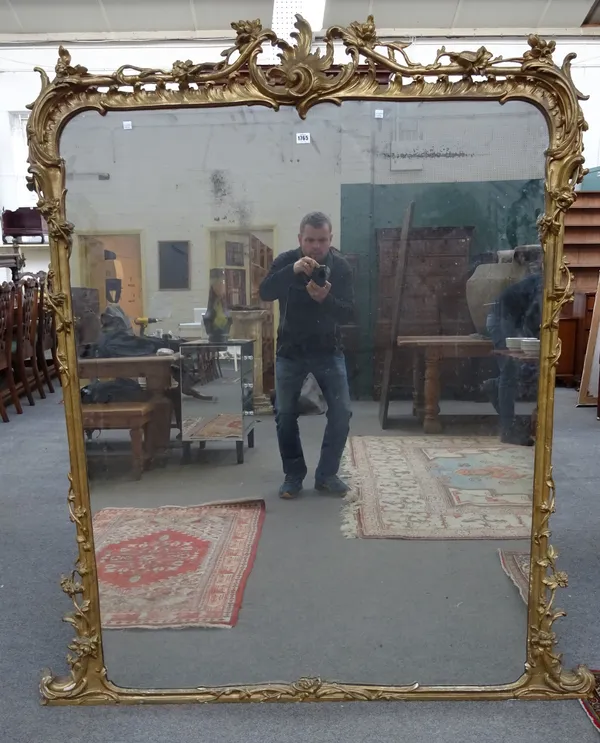 A 19th century Continental giltwood and composition overmantel mirror, the shaped rectangular plate within scrolling floral frame, 150cm wide x 172,5c