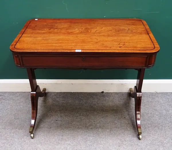 A Regency inlaid mahogany combination library/writing table, the rectangular lift top enclosing a fitted interior, on trestle end standards and four d