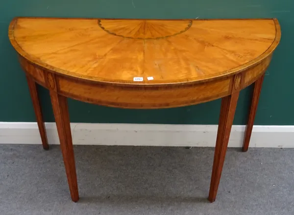 A George III and later satinwood, box and ebony strung demi-lune console table, the lunette and radial veneered top above patera headed square taperin