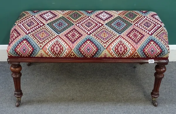 A late Victorian oak framed rectangular footstool, kelim style upholstery, on twisted tapering supports, with cappings and castors, 93.5cm wide x 44cm