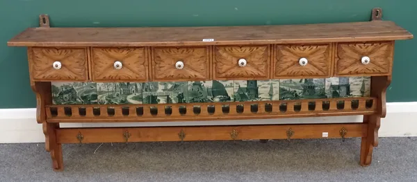 A late 19th century Continental pine and mixed wood hanging spice rack, five drawers above a green and white printed tile back, shelf and hooks below,