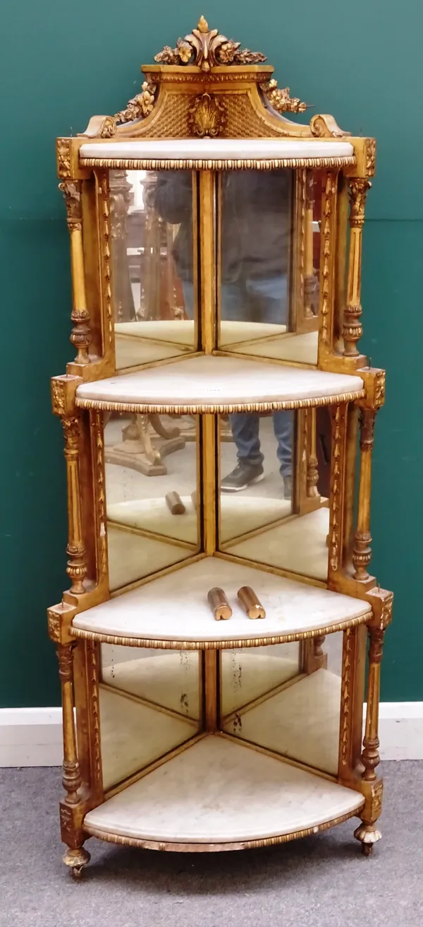 A late 19th century giltwood and white marble inset four tier set of corner shelves, shell and foliate decorated frame above part graduated mirror bac