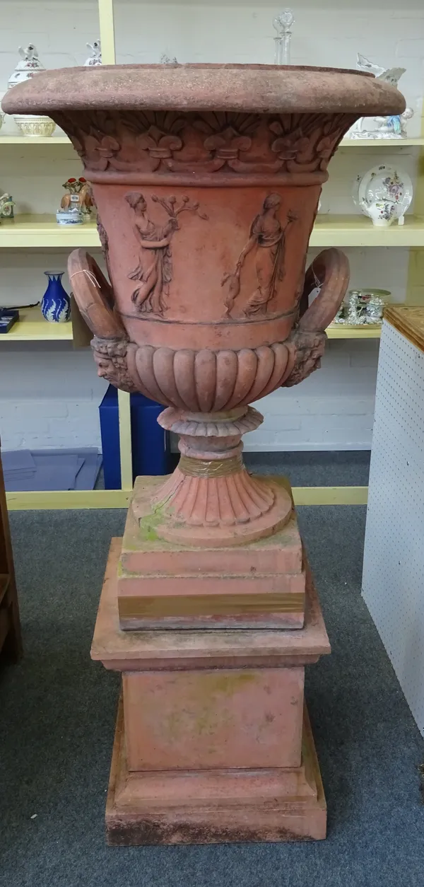 A pair of large terracotta twin handled garden urns, relief moulded with classical figures on fluted socles and shaped square plinths, 75cm diameter x