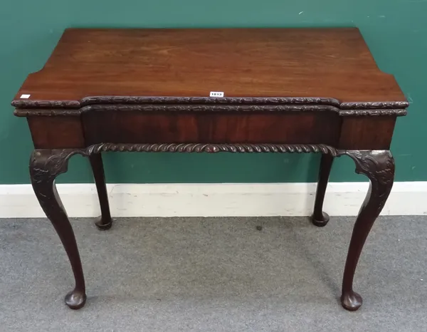 A George II carved mahogany card table, the foldover inverted rectangular top on four cabriole supports and pad feet, 92cm wide x 73cm high x 45cm dee