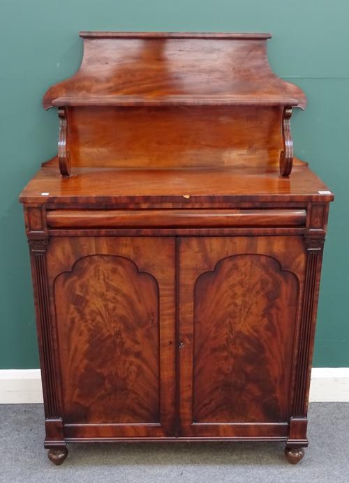 A Regency mahogany chiffonier, the shaped two tier back over cushion drawer and pair of arch panel cupboards, 88cm wide x 136cm high x 36cm deep.