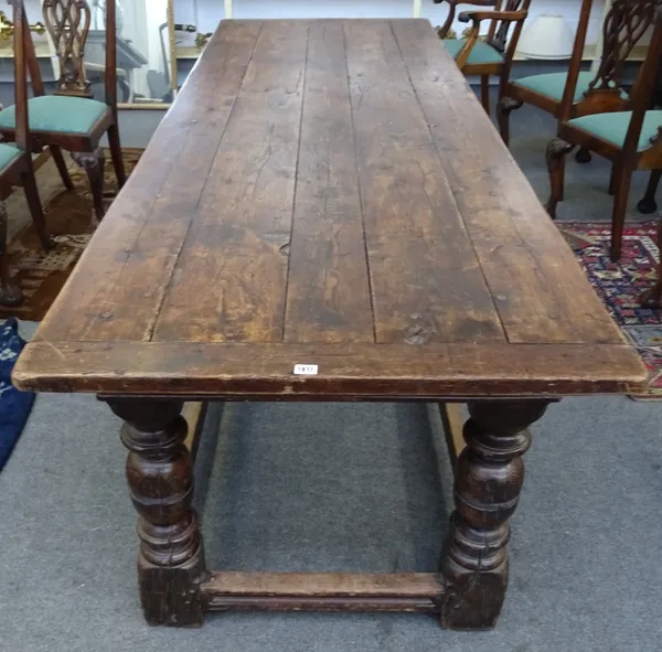 An oak refectory table, the cleated five plank top on cup and cover turned supports, united by perimeter stretcher, 275cm long x 92cm wide x 79cm high