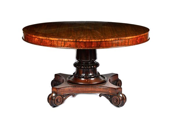 A William IV rosewood breakfast table, the circular snap top on a substantial lappet carved column, with quatrefoil platform and scroll feet, 133cm wi