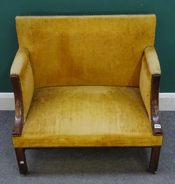 A George III and later mahogany framed wide low chair, mustard yellow upholstered back, arms and seat, on chamfered square section legs, united by str