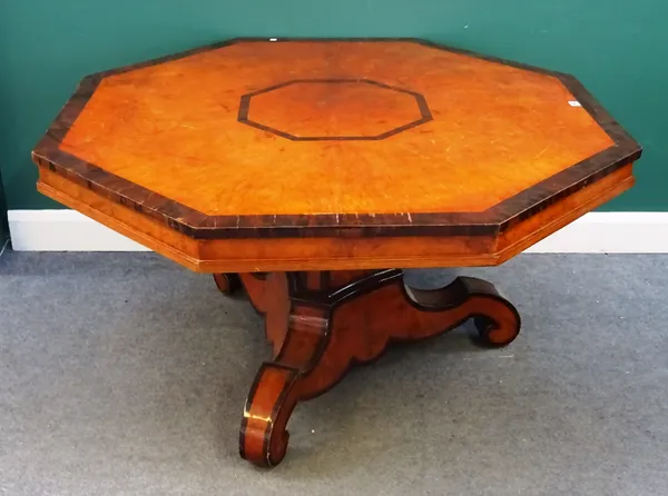 An early Victorian amboyna and rosewood banded octagonal snap top centre table, on triangular column and three downswept supports, 130cm wide x 73cm h