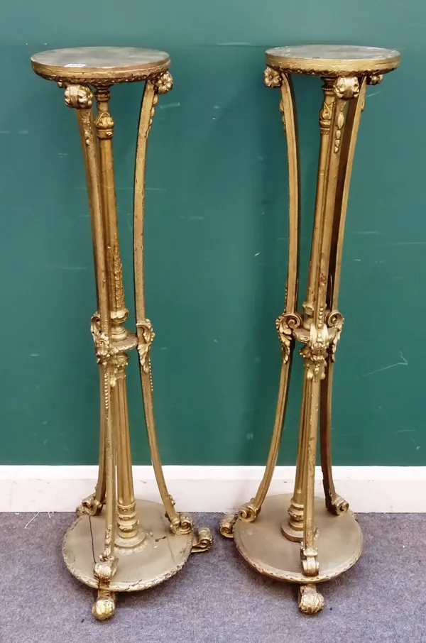 A pair of 18th century style gilt torchère stands, each on three floral moulded supports and circular base, 40cm wide x 123cm high (2).