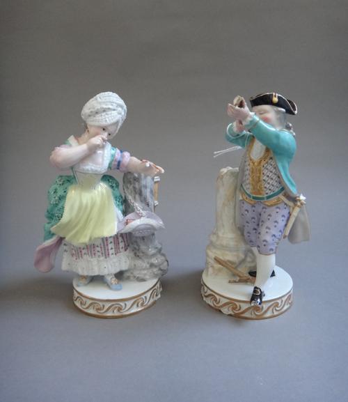 A pair of Meissen figures of archers, circa 1880, modelled as a young man and woman standing beside a broken column, he firing a crossbow, his compani