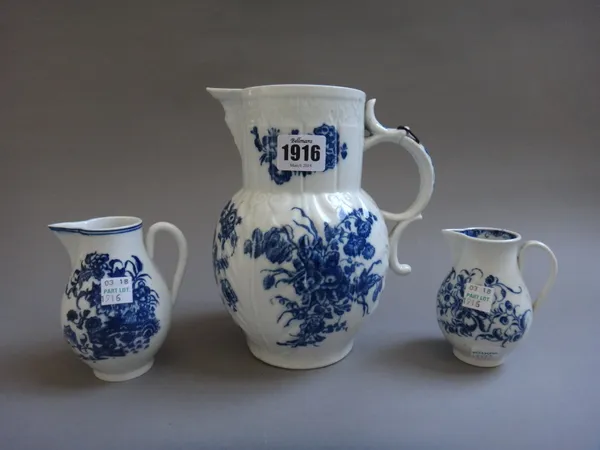 A Caughley porcelain mask jug, circa 1780, printed with `The Three Flowers' pattern,  19.5cm high, and two Caughley blue and white sparrow beak jugs,