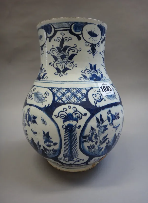 A rare English delftware blue and white cistern, probably Bristol, circa 1720-40, of flattened pear form, the bulbous body painted with panels of flow