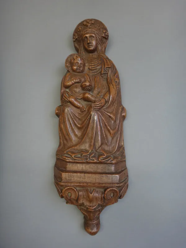 A patinated terracotta plaque, late 19th century, depicting the Holy Mother and Child on a shrine, 42cm high.