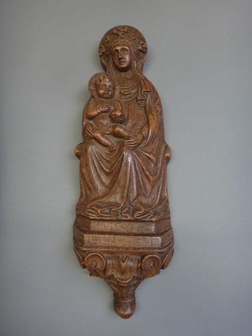 A patinated terracotta plaque, late 19th century, depicting the Holy Mother and Child on a shrine, 42cm high.