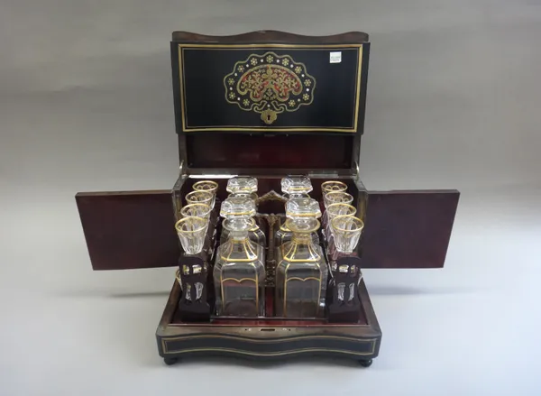 A 19th century gilt glass liqueur set, of square canted form, comprising; four decanters and stoppers and sixteen glasses, contained in a hardwood and