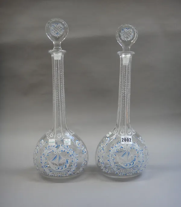 A pair of 20th century glass and foliate enamel decorated decanters and stoppers each detailed with a sailing ship and with long neck, 43cm high, (2).