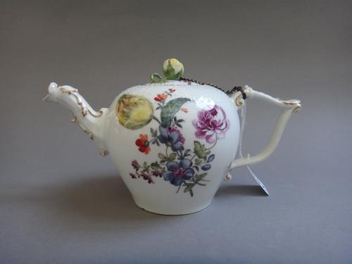 A Meissen porcelain teapot, circa. 1760, foliate decorated with a basket weave moulded top and figural spout, blue crossed swords mark. 11cm high.