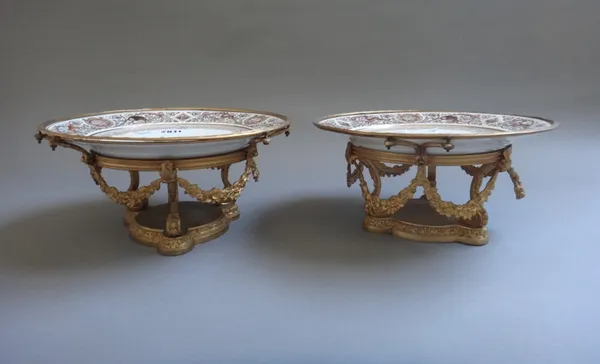 A pair of Sèvres style 'Royal Hunting' pattern comports, mid-19th century or later, the porcelain plates set in a foliate cast brass base marked to th