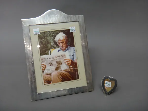 A silver mounted shaped rectangular photograph frame, with banded decoration, by William Comyns, London 1910 and a Victorian silver mounted small hear