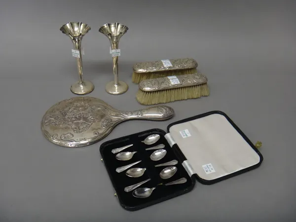 Silver mounted wares, comprising; a hand mirror, with floral embossed decoration, Birmingham 1909, two similar clothes brushes, Chester 1901 and 1902,