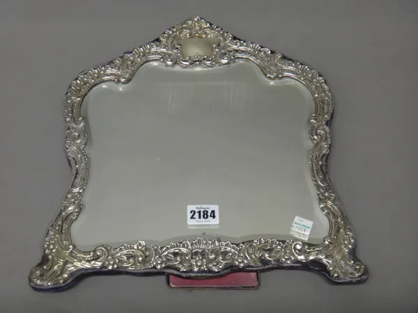 A silver mounted strut backed mirror, of rococo cartouche shaped form, with floral and scroll embossed decoration, fitted with a bevelled glass, Birmi