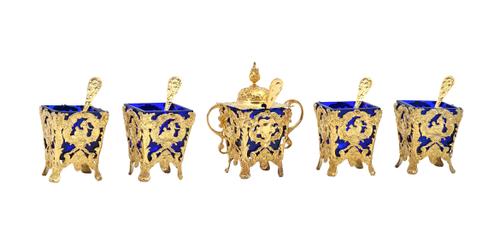 A Victorian silver gilt part condiment set, comprising; one twin handled hinge lidded mustard pot, four salts and five salt spoons, the mustard pot an