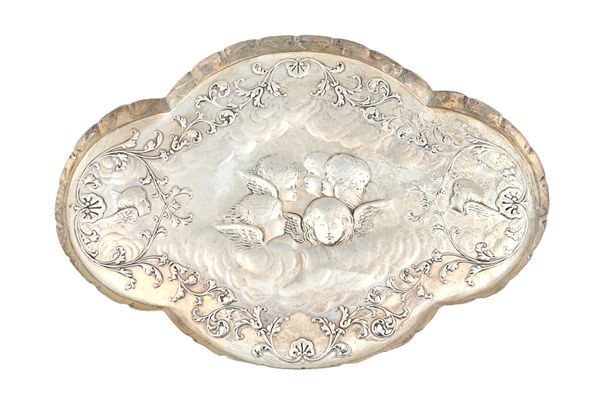 A late Victorian silver shaped oval dressing table tray, the centre embossed with a group of cherubs faces, with a further cherub's face at either sid