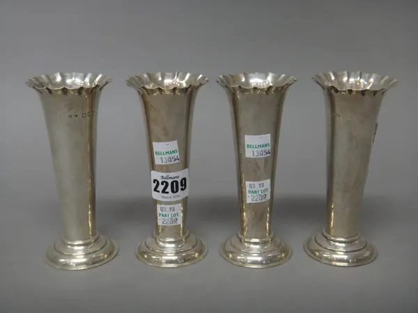 A set of four silver vases, each of tapering cylindrical form, with a flared rim and raised on a loaded circular foot, sample height 13cm, London 1900