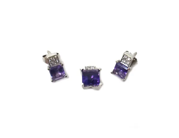 A white gold, amethyst and diamond pendant, claw set with a square step cut amethyst below a diamond set four stone surmount, detailed 750 CB and a pa