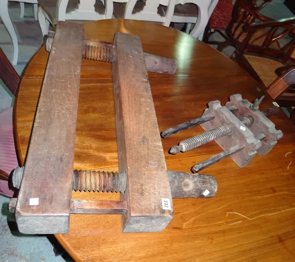 A large 19th century wooden leg vice, 91cm high, and an early 20th century wooden bench vice, (2).  G7