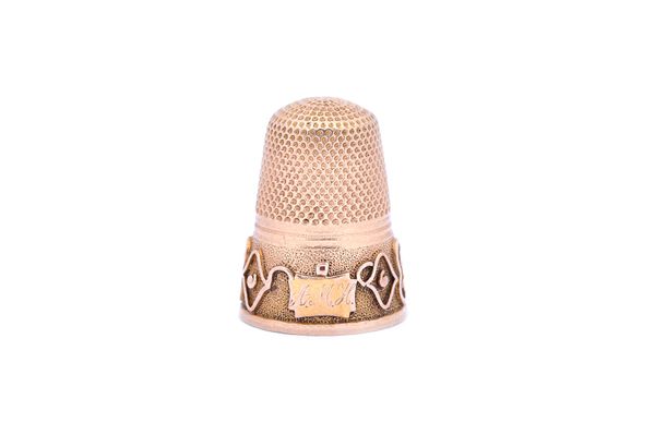 A gold thimble, probably last quarter of the 19th century, having a decorated band to the rim and with an initial engraved shaped rectangular cartouch