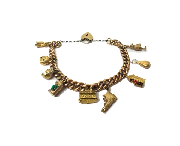 A 9ct gold graduated solid curb link charm bracelet, with a 9ct gold heart shaped padlock clasp, fitted with nine mostly 9ct gold pendants and charms,