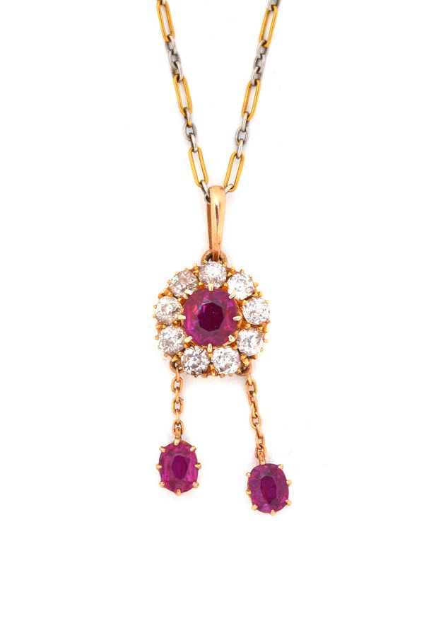 A gold, ruby and diamond set cluster pendant necklace, claw set with the principal cushion shaped ruby in a surround of nine cushion shaped diamonds,