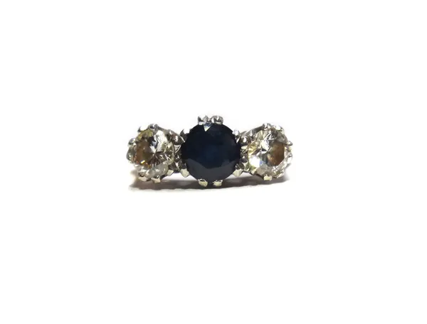 A gold, sapphire and diamond set three stone ring, mounted with a circular cut sapphire at the centre, between two circular cut diamonds, detailed 18