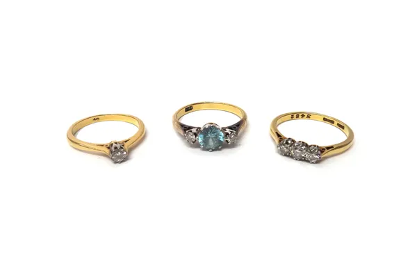 A gold, diamond and blue zircon set three stone ring, claw set with the circular cut blue zircon at the centre, detailed 18 CT, a gold and platinum, d