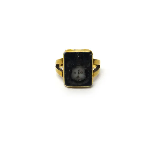 A gold and banded agate rectangular signet ring, hinged with a locket compartment, the agate intaglio carved as a shield, a crest and a motto, detaile