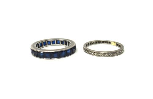 A sapphire set full eternity ring, mounted with square step cut sapphires, ring size M and a half and a diamond set eternity ring, mounted with small
