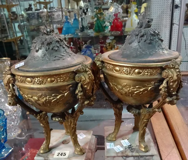 A pair of 20th century gilt metal lidded urns on marble bases, (2). D1