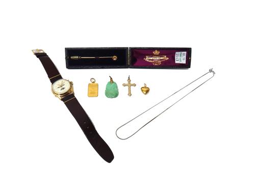 A carved jade pendant, a heart shaped pendant, a gilt metal pendant cross, a Credit Suisse 5 gram fine gold ingot pendant, a gold and diamond set sing