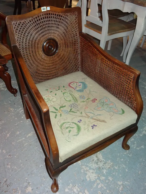 A 20th century mahogany bergere chair, on pad feet.  H7