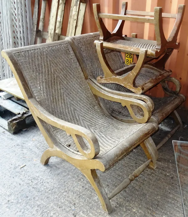 A pair of early 20th century stained pine plantation chairs, with wicker backs, together with matching footstools, (4).   OUT
