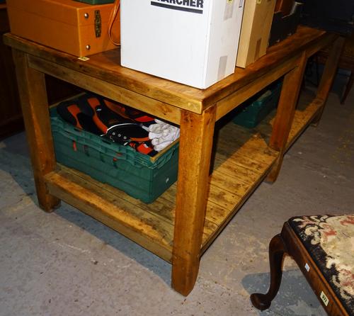 An early 20th century stained pine preparation table, with platform undertier, on square block supports, 188cm wide x 80cm high. K1