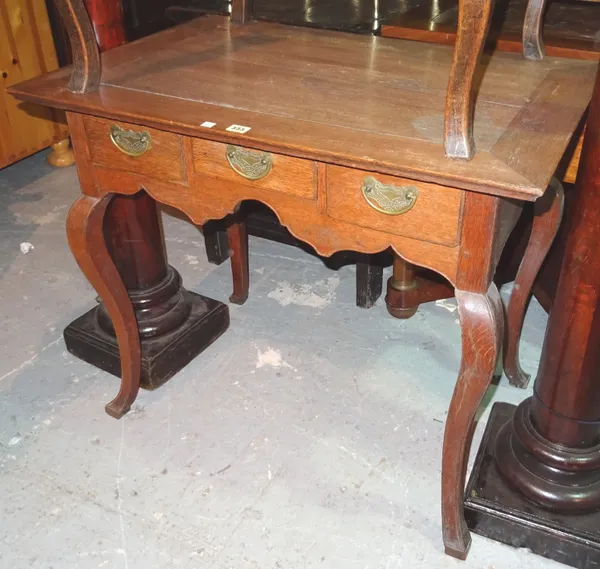 An early 20th century Continental oak writing desk, with three frieze drawers, on sabre supports, 88cm wide x 74cm high.  I9