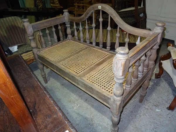 A Victorian hall bench, with wicker seat and spindle back, on turned supports, 121cm wide x 100cm high.  L5