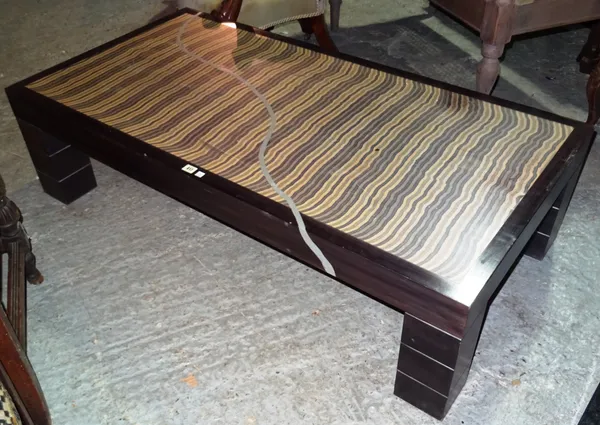 A 20th century hardwood rectangular coffee table, with specimen wood top on four block supports, 141cm wide x 38cm high.   J4