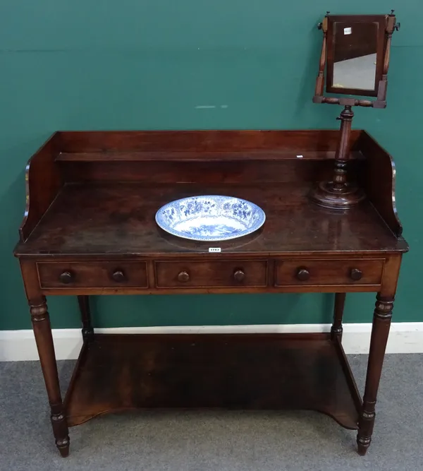 An early 19th century mahogany washstand, with galleried back and inset ceramic wash bowl, over a pair of frieze drawers on turned supports, united by