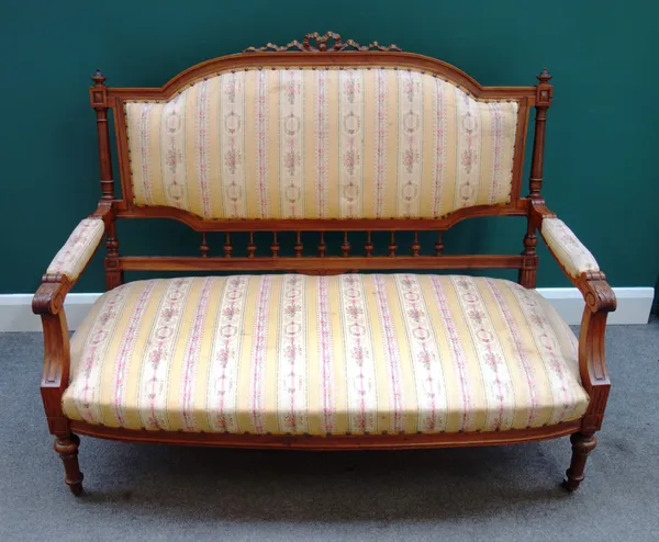 A late 19th century walnut show frame sofa, with ribbon carved crest and bow seat, on turned supports, 137cm wide x 108cm high x 70cm deep.  J4
